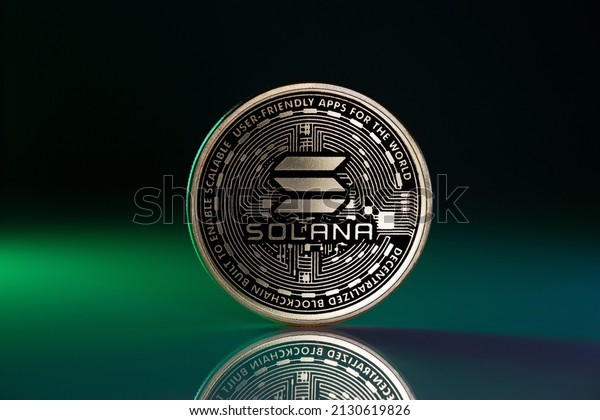 Solana SOL Physical Coin Placed on Reflective\
Surface and lit with green\
light