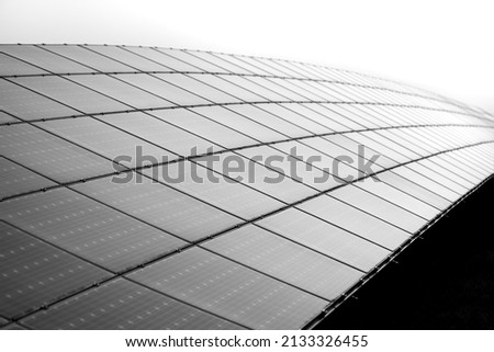 Solar cell panels mounted in a framework on a hilltop in Germany. Sunlight as a source of energy to generate direct current electricity – ecologic renewable power. Black and white greyscale gradient.