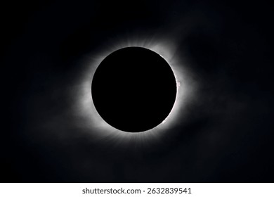 Solar eclipse at totality seen through clouds with the corona and flares visible