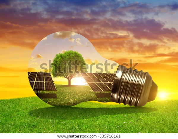 Solar energy panels in light bulb at sunset.\
The concept of sustainable\
resources.
