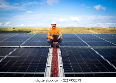 Solar Energy Worker Or Engineer With His Laptop Computer Checking Installation And Productivity Of New Solar Power Plant.