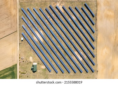 Solar Farm Aerial View, Rows Of PV Panels By A Small House