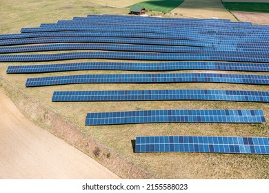 Solar Farm Aerial View, Rows Of PV Panels By A Small House