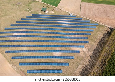 Solar Farm Aerial View, Rows Of PV Panels By A Small House