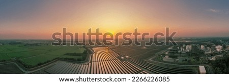 Solar Farm (solar cell) at sunset sky background with electric power generation in agricultural area . Renewable green alternative energy. Power plant. Solar photovoltaic rows array ground mounting.