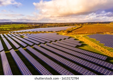 A solar farm, with thousands of Solar Panels capturing the sun's natural light and converting it into renewable, sustainable energy due to the ongoing climate change, natural energy in rural fields