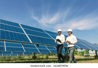 The solar farm(solar panel) with two engineers walk to check the operation of the system, Alternative energy to conserve the world's energy, Photovoltaic module idea for clean energy production. - Shutterstock ID 1614874936