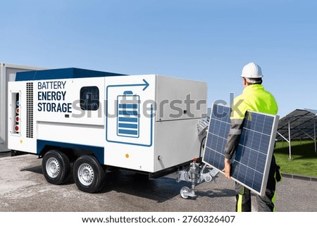 Solar installer with panel passing a mobile energy storage trailer