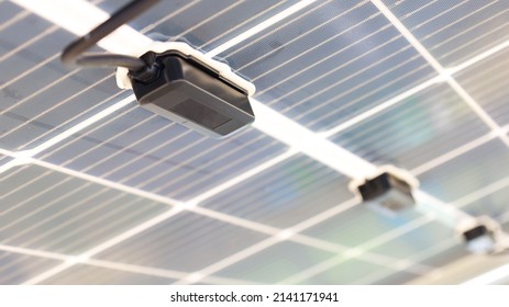 Solar junction box. A row of black diode blocks is mounted under the solar panels in a smart farm. Close-up focus and subject selection