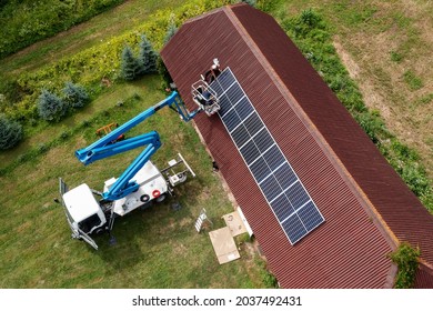 Solar Panel Installation On A Red Barn Roof.