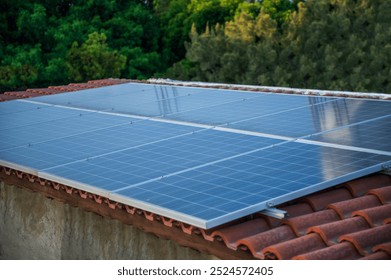 Solar Panel on The House Roof, on Red Tiled Roof with a tree background