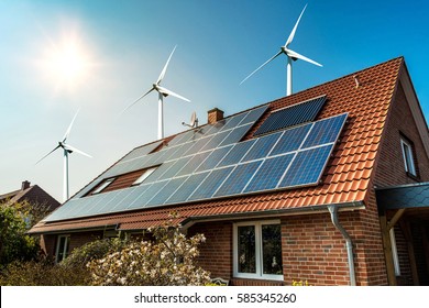 Solar panel on a roof of a house and wind turbins arround - concept of sustainable resources