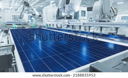 Solar Panel Production Process at Modern Bright Automated Factory. Robot Arm on Assembly Line is Placing Solar Cells.