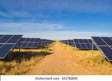 Solar Panel Rows On Solar Farm In South-Africa With Blue Sky And Gravel Road