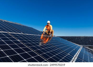 Solar panel technician with drill installing solar panels on house roof on a sunny day. - Powered by Shutterstock