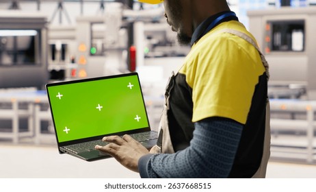 Solar panels factory engineer analyzes performance data with green screen laptop to predict gear failures. Photovoltaics plant worker uses mockup notebook to follow maintenance procedures, camera B
