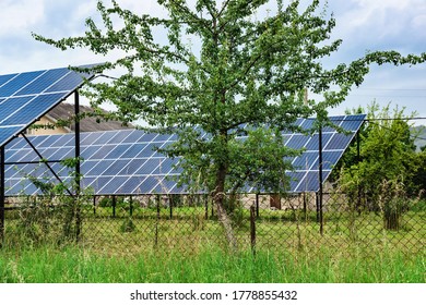 Solar panels in the garden. Solar power plant among trees and bushes. - Shutterstock ID 1778855432