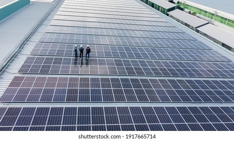 Solar panels installed on a roof of a large industrial building or a warehouse. Industrial buildings in the background. Horizontal photo. - Shutterstock ID 1917665714