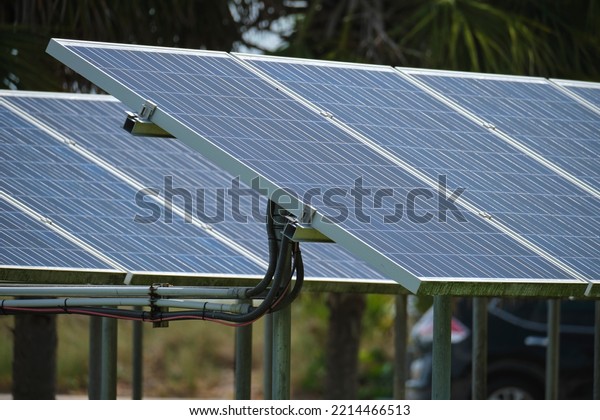 Solar\
panels installed on stand frame near parking lot for effective\
generation of clean electricity. Photovoltaic technology integrated\
in urban infrastructure for electric car\
charging