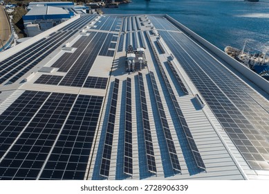 Solar panels installing on a large industrial building roof next to a harbor generating clean energy