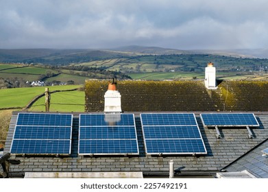 Solar panels on a domestic house roof with a beautiful countryside view behind. Clean renewable energy with zero carbon emissions. Electricity generation from the sun. Solar energy. Copy space. - Shutterstock ID 2257492191