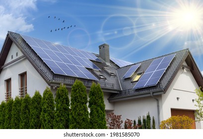 Solar panels on a gable roof. Beautiful, large modern house and solar energy. Rays of the sun.