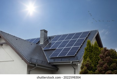 Solar panels on a gable roof. Beautiful, modern house and solar energy. Rays of the sun. - Shutterstock ID 2022598304