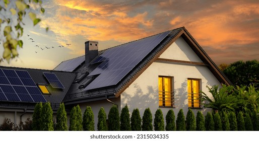 Solar panels on a gable roof. Large modern house and solar energy. Sunset. - Shutterstock ID 2315034335