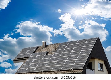 Solar panels on a house roof, in the bright sun - Shutterstock ID 1925566184
