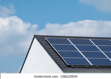 Solar Panels On The Roof Of A Family House. Blue Sky With Clouds.