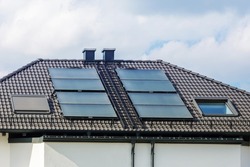 Solar Panels On Roof Of House. Tiled Roof With Windows With Shutters, Chimneys, Snow Guards, Ladders And Electrically Heated Gutters. Roof Of Duplex House.