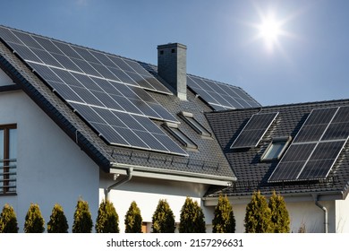 A solar panels on the roof of the house with a blue sky on the background - Shutterstock ID 2157296631