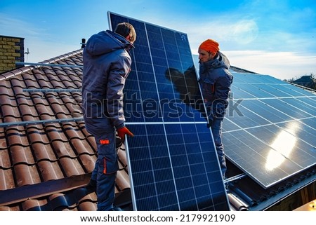 Solar panels on roof.  Installing a Solar Cell on a Roof. Workers installing solar cell farm power plant eco technology.