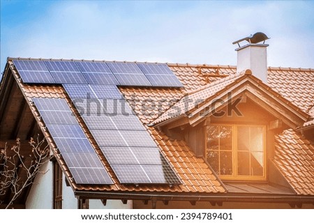 Solar Panels on Roof of Private Old House with Roof Window and Sun Light. Solar Panel Energy System.