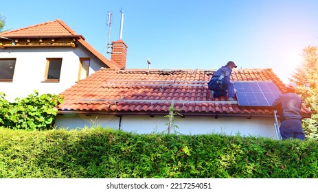 Solar Panels On Roof. Workers Installing Solar Cell Farm Power Plant.