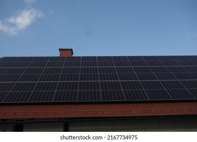 Solar Panels On The Rooftop Of A House, Using Renewable Energy In Modern Buildings