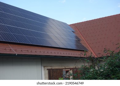 Solar Panels On The Rooftop Of A House, Using Renewable Energy In Modern Buildings