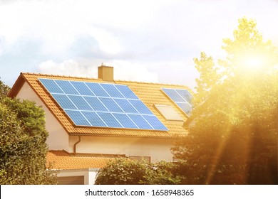 Solar panels on the tiled roof of the building in the sun. - Shutterstock ID 1658948365