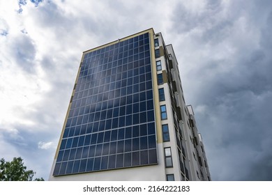 Solar Panels On The Wall Of A Multi-storey Building On Storm Clouds Background. Renewable Solar Energy. An Energy-efficient Home That Uses The Energy Of The Earth, Sun, Air And Wastewater