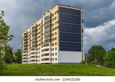 Solar Panels On The Wall Of A Multi-storey Building On Storm Clouds Background. Renewable Solar Energy. An Energy-efficient Home That Uses The Energy Of The Earth, Sun, Air And Wastewater