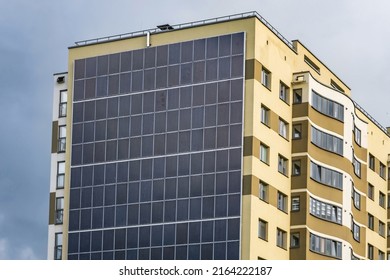 Solar Panels On The Wall Of A Multi-storey Building On Storm Clouds Background. Renewable Solar Energy. An Energy-efficient Home That Uses The Energy Of The Earth, Sun, Air And Wastewater