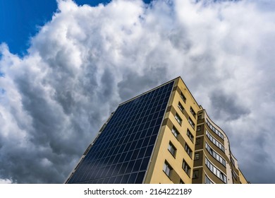 Solar Panels On The Wall Of A Multi-storey Building On Storm Clouds Background. Renewable Solar Energy. An Energy-efficient Home That Uses The Energy Of The Earth, Sun, Air And Wastewater