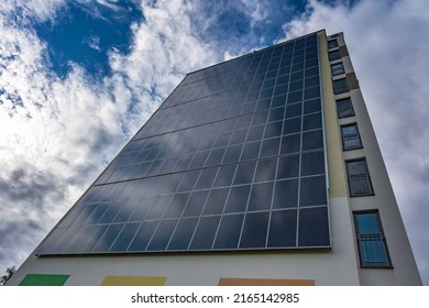 Solar Panels On The Wall Of A Multi-storey Building On Storm Clouds Background. Renewable Solar Energy. An Energy-efficient Home That Uses The Energy Of The Earth, Sun, Air And Wastewater