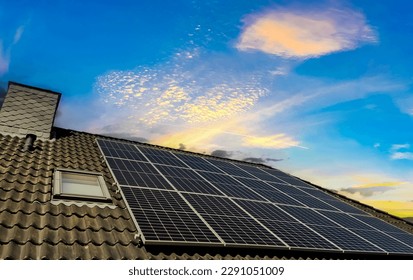 Solar panels producing clean energy on a roof of a residential house during sunset - Shutterstock ID 2291051009