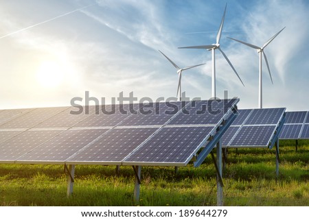 solar panels and wind generators under blue sky on sunset