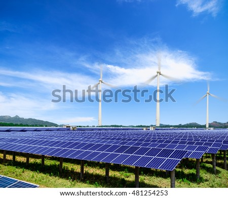 solar panels and wind generators under blue sky on sunset