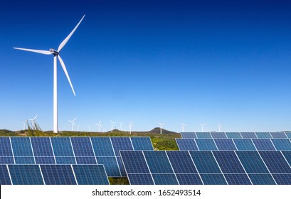 solar panels with wind turbines  against blue sky 