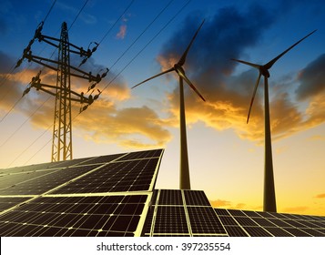 Solar panels with wind turbines and electricity pylon at sunset. Clean energy concept.