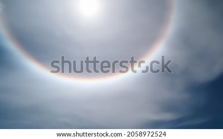 Solar phenomenon around halo the sun. Part bright spots of a solar halo colors rainbow white ring encircle near Center of Sun. Radiation aurora natural light displays in Sky. Soft blurry picture