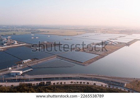 Solar Photovoltaic of solar farm aerial view, solar plant rows array of on the water mount system Installation in earthen pond, Floating solar or floating photovoltaics (FPV). Morning scene,